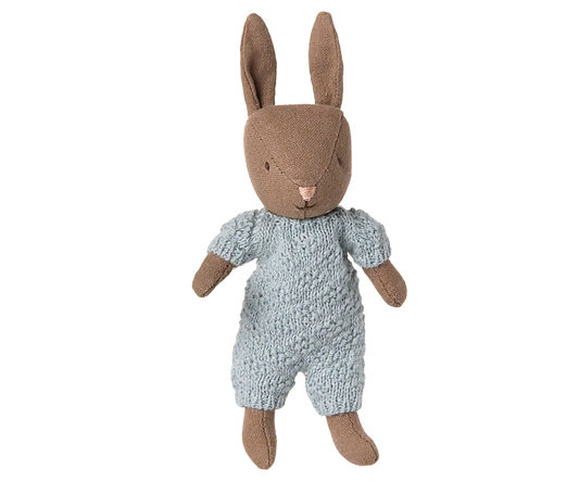 Stuffed toy rabbit wearing a knitted outfit on a white background
