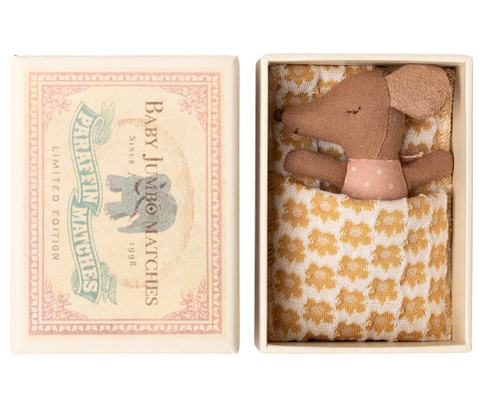 Small brown teddy bear in a decorative box with a floral pattern