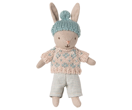Toy rabbit wearing a knitted sweater and hat on a white background