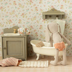 Miniature bathroom set with bathtub, sink, and toy rabbit against a floral wallpaper background | Maileg UK