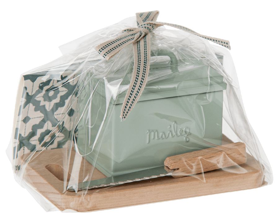 Maileg metal pastel bread tin with mini wooden chopping board, bread knife and loaf shown here in its packaging with a bow | Dollhouse Miniatures