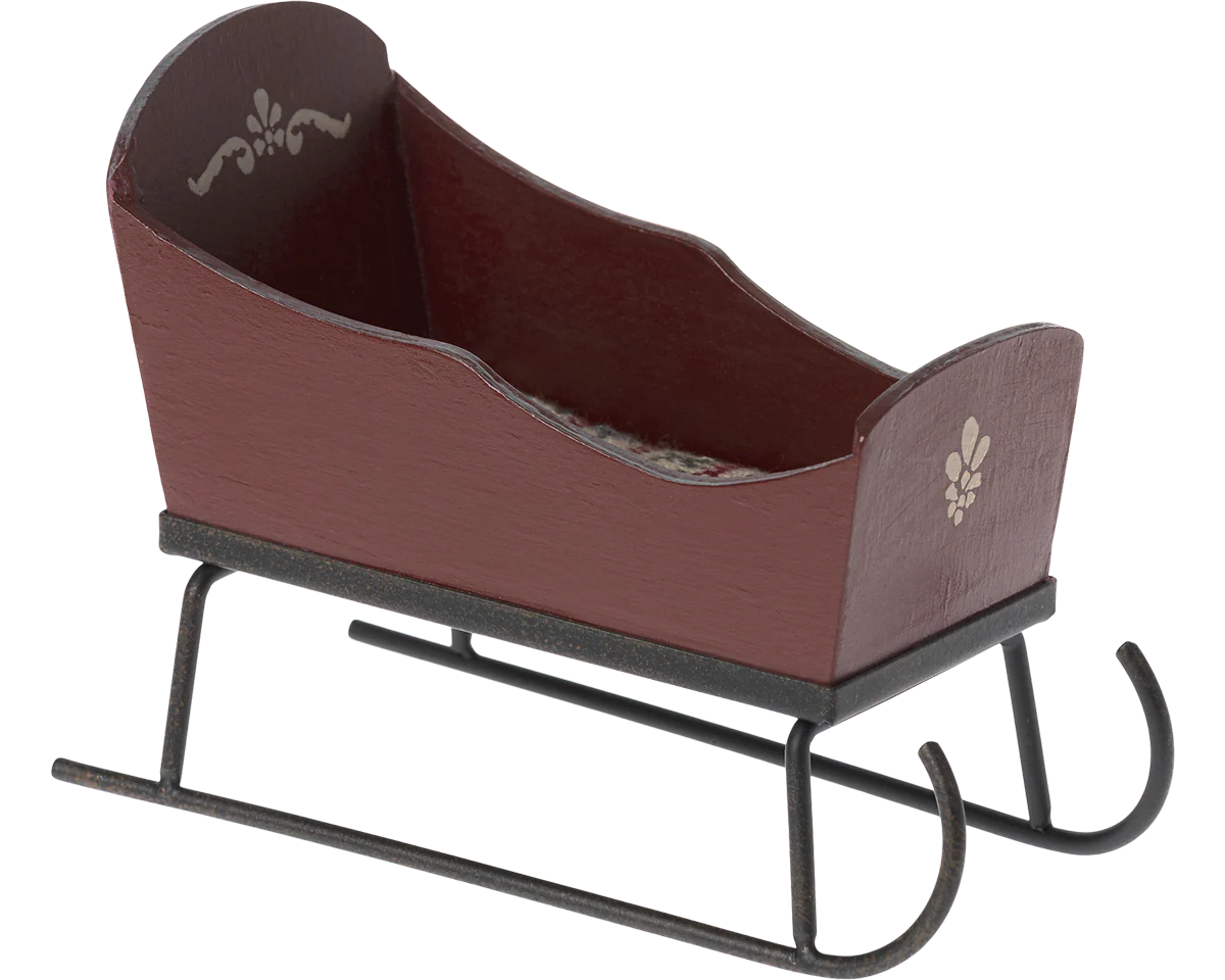 Brown wooden sleigh with black metal runners on a white background