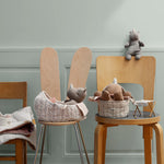 Wooden chairs with toys and baskets against a light gray wall | Maileg UK
