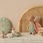 Children's toys and dolls on a neutral background with a wicker chair and decorative items. | Maileg UK