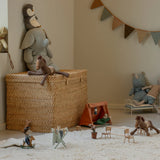 Children's toys and playset in a room with a woven basket and decorative elements.