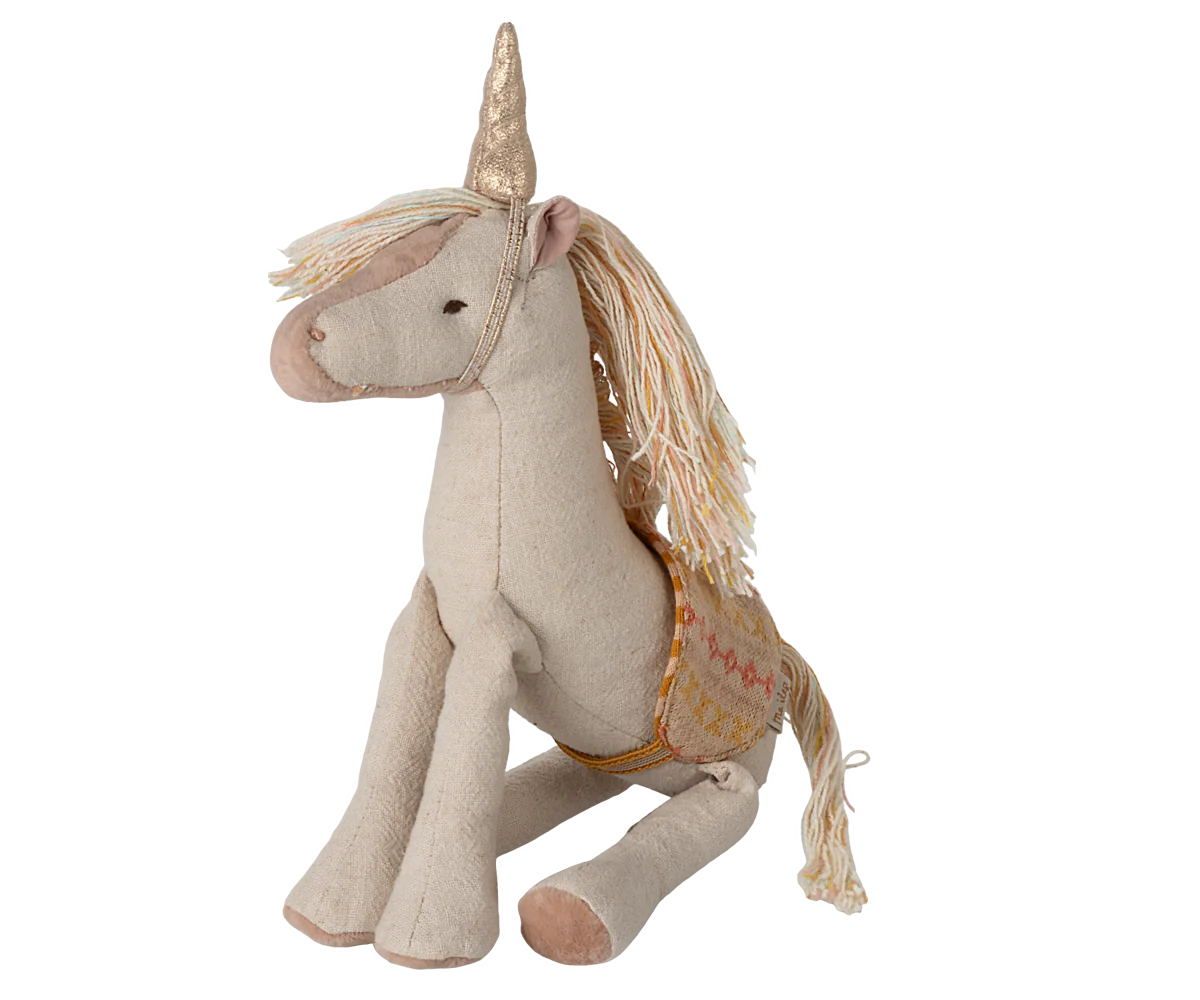 A small plush unicorn toy with a golden horn and a saddle, predominantly in beige and white colors.