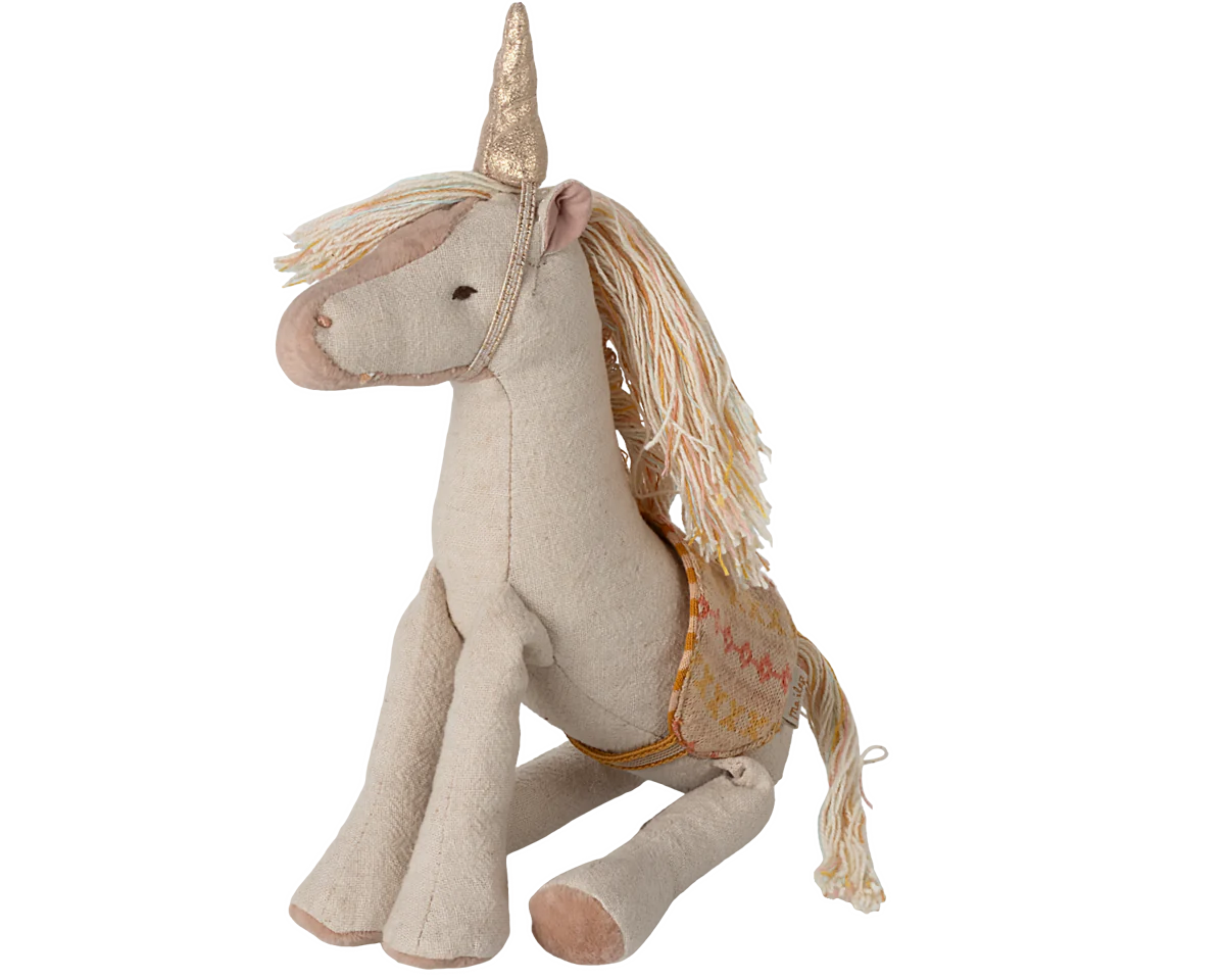 A small plush unicorn toy with a golden horn and a saddle, predominantly in beige and white colors.