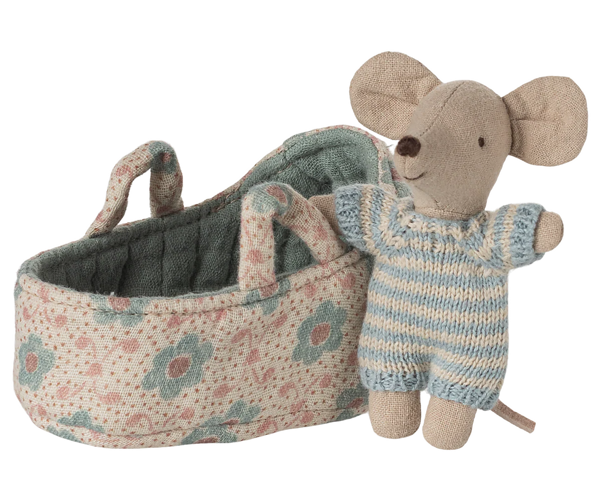 Toy mouse in overalls standing next to a floral-patterned baby carriage on a white background