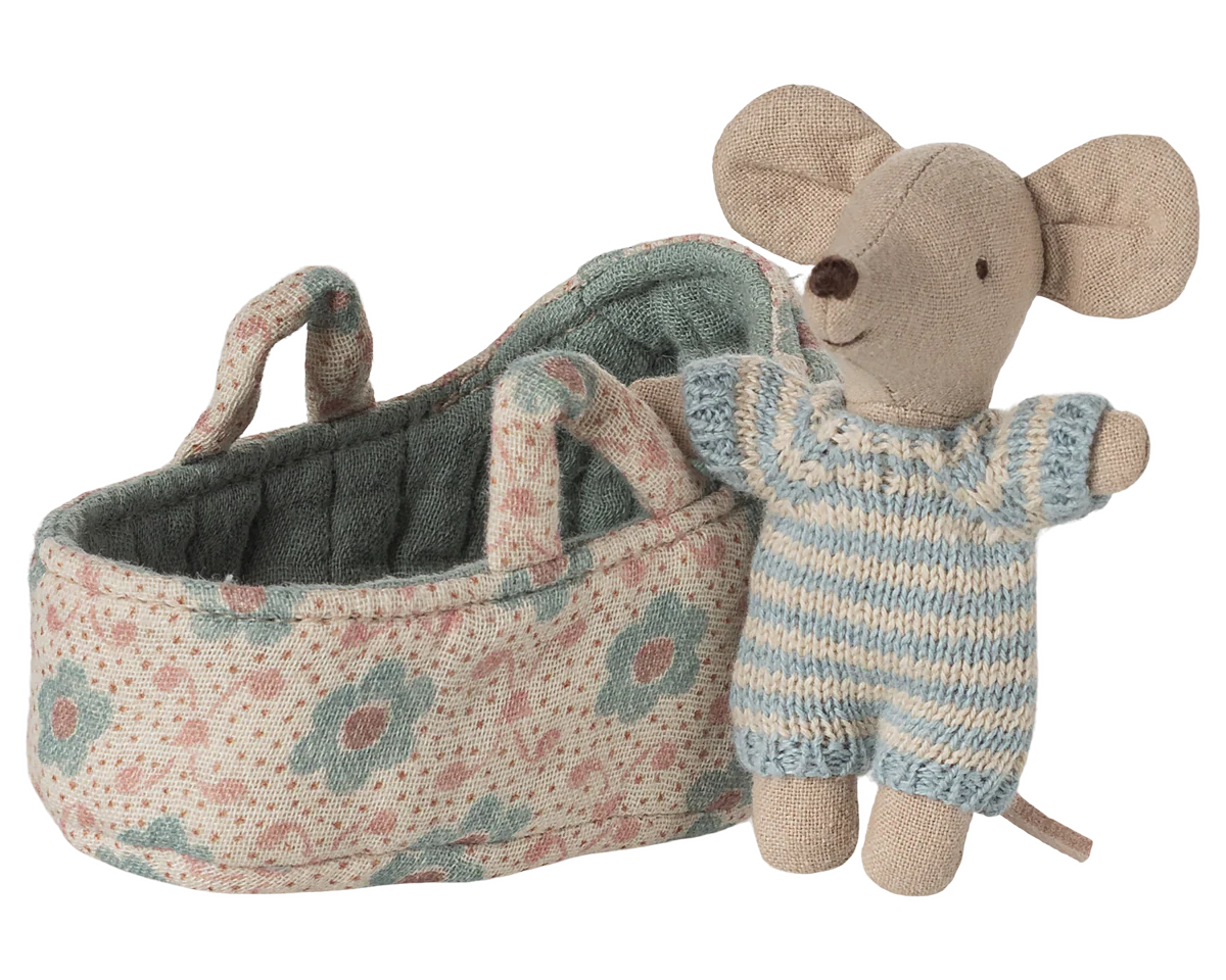 Toy mouse in overalls standing next to a floral-patterned baby carriage on a white background