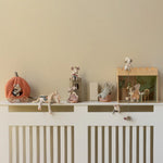 Decorative shelf with small figurines on a white cabinet against a beige wall | Maileg UK