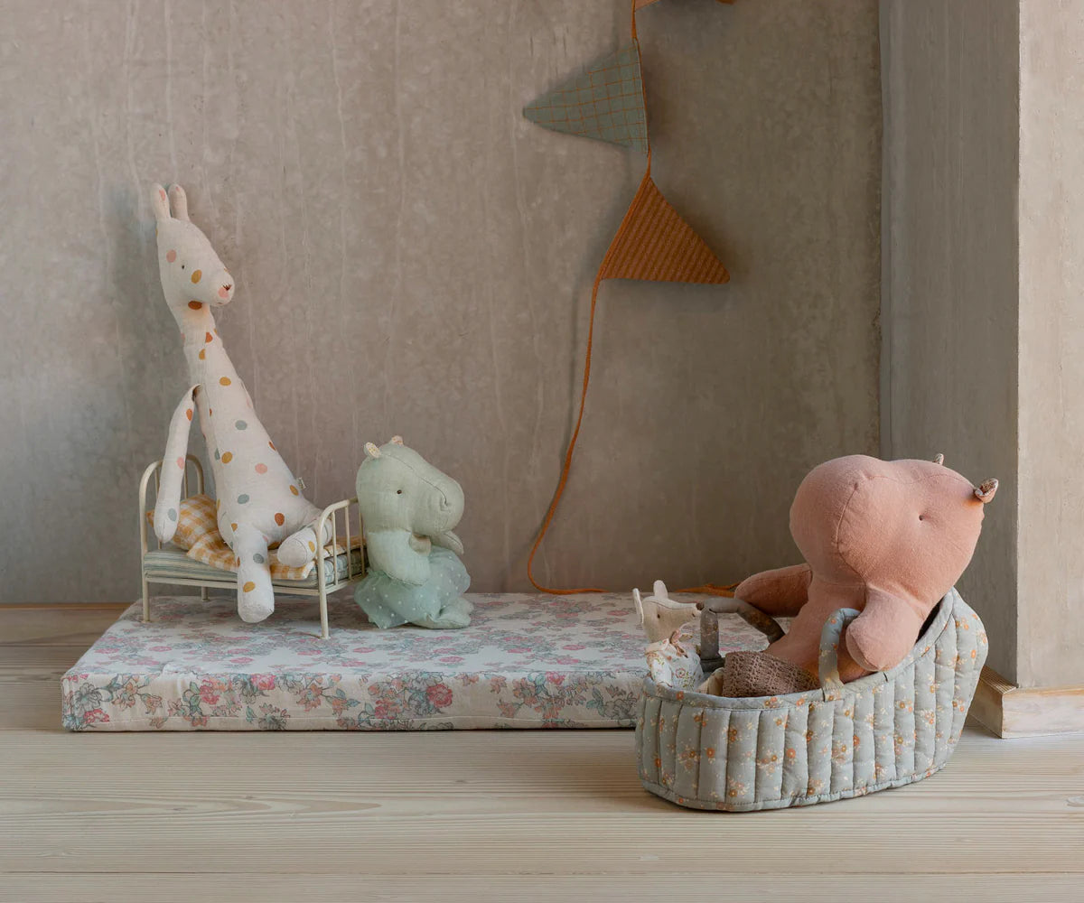 Children's room with stuffed animals on a floral bedspread and wall decorations. | Maileg UK
