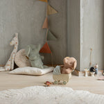 Children's toys and plushies on a wooden floor against a neutral wall. | Maileg uk