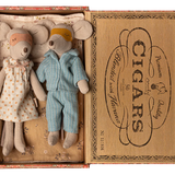 Two toy mice, a girl in a dress and a boy in overalls, inside an open cigar box with decorative text. | Maileg UK
