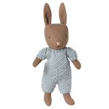 Stuffed toy rabbit wearing a knitted outfit on a white background