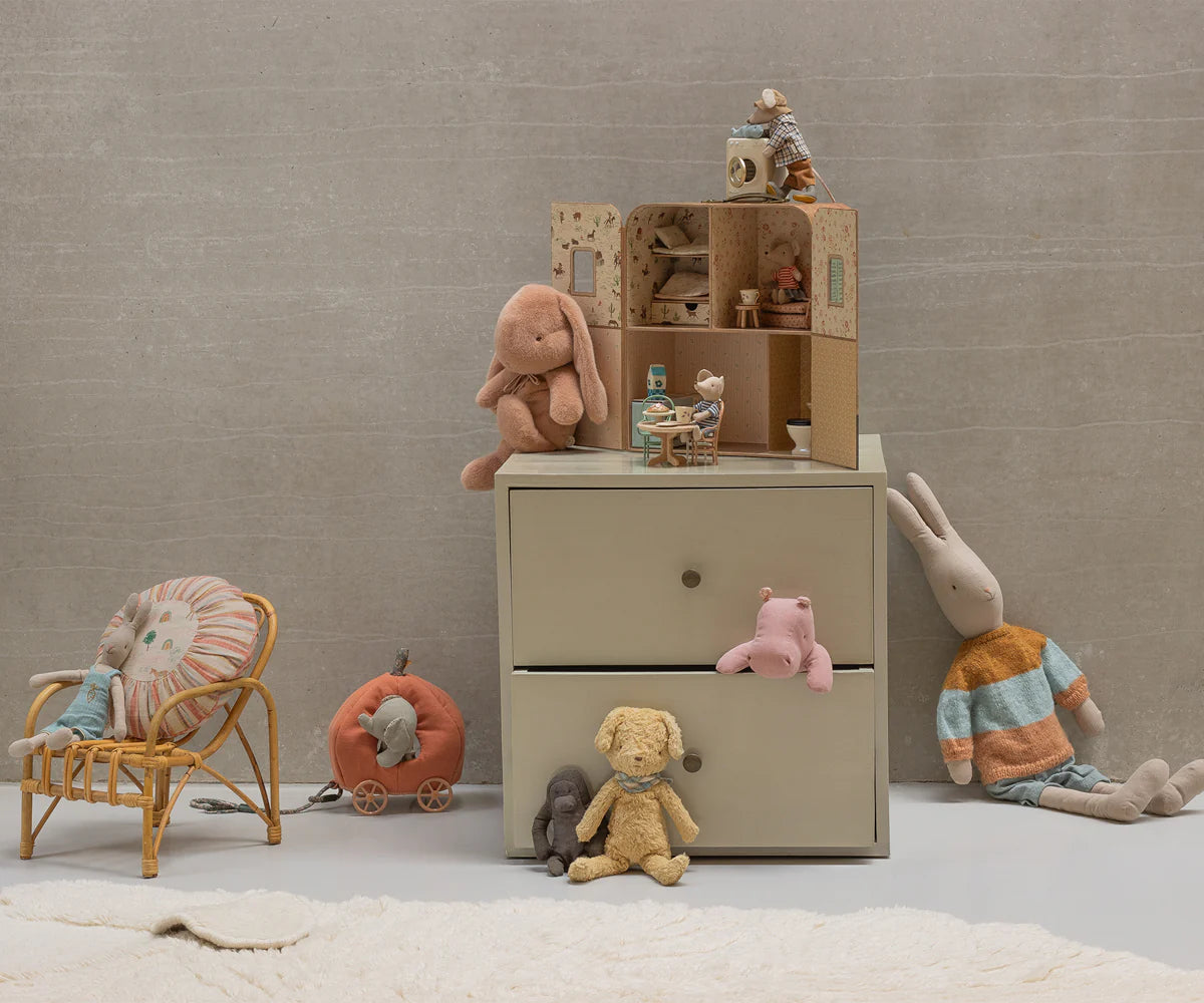 Children's room with a dresser, toys, and a chair against a plain wall. | Maileg UK