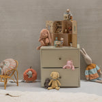 Children's room with a dresser, toys, and a chair against a plain wall. | Maileg UK