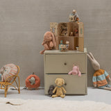 Children's room with a dresser, toys, and a chair against a plain wall. | Maileg UK