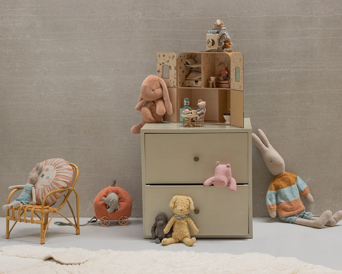 Children's room with a dresser, toys, and a chair against a plain wall. | Maileg UK