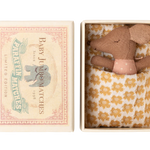 Small brown teddy bear in a decorative box with a floral pattern