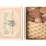 Small brown teddy bear in a decorative box with a floral pattern