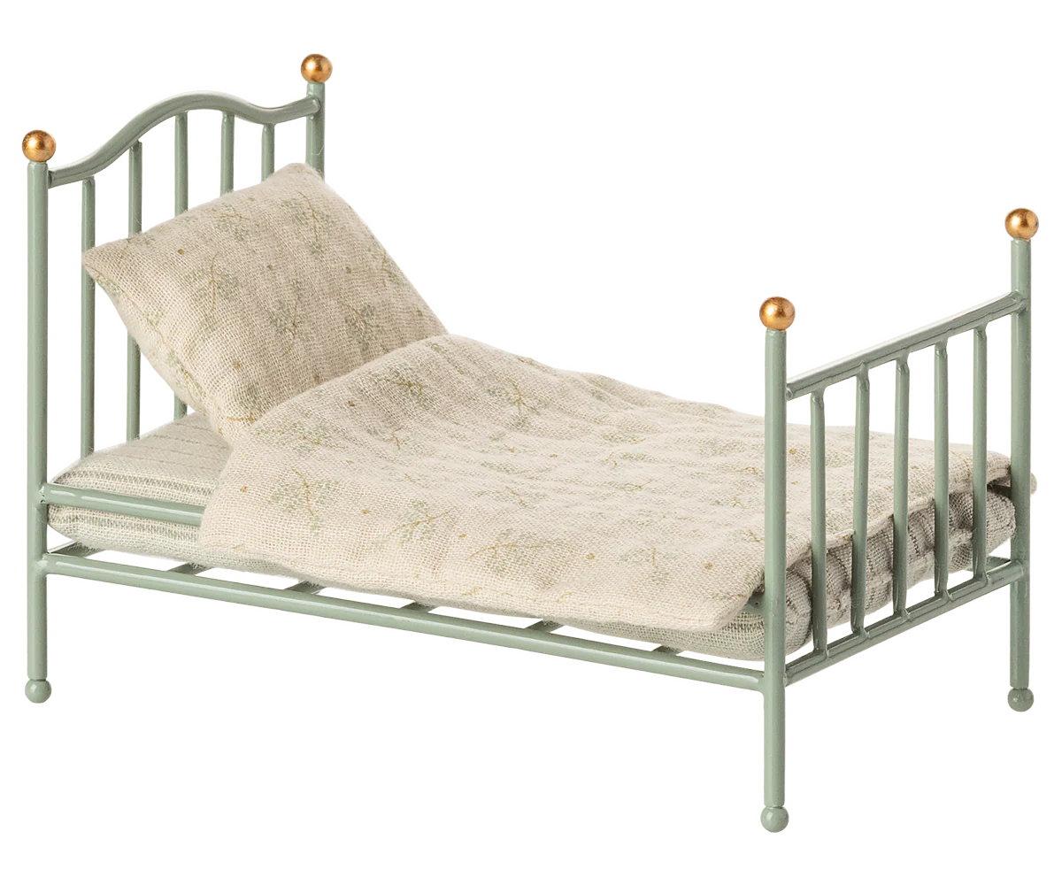 Small green metal bed with beige bedding on a white background | Maileg UK