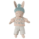 Toy rabbit wearing a knitted sweater and hat on a white background