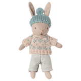 Toy rabbit wearing a knitted sweater and hat on a white background