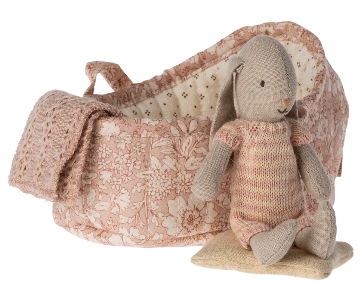 Collectable Bunny in its own carry basket with pillow and blanket in a floral design, bunny is wearing a knitted striped all in one.