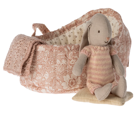 Collectable Bunny in its own carry basket with pillow and blanket in a floral design, bunny is wearing a knitted striped all in one.