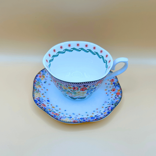 showing the detailing on the inside rim of the tea cup and the cath kidton floral pattern on the saucer from above, a colourful vintage design