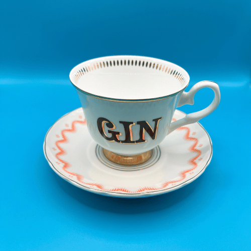 Yvonne Ellen Boozy cup and saucer with the slogan gin with gold accents on a blue teacup which sits on a with bone china dainty saucer with pastel detailing. A gorgeous addition to any tea party