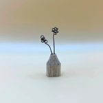 Small wooden vase with wire flowers on a gradient background