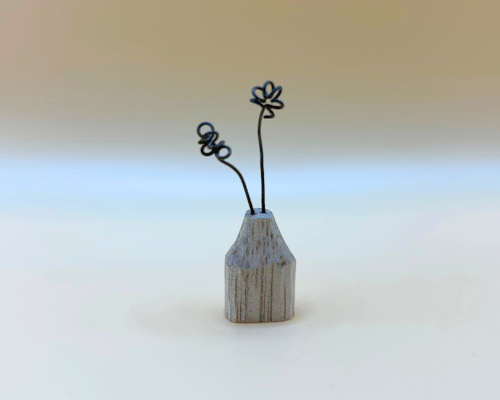 Small wooden vase with wire flowers on a gradient background