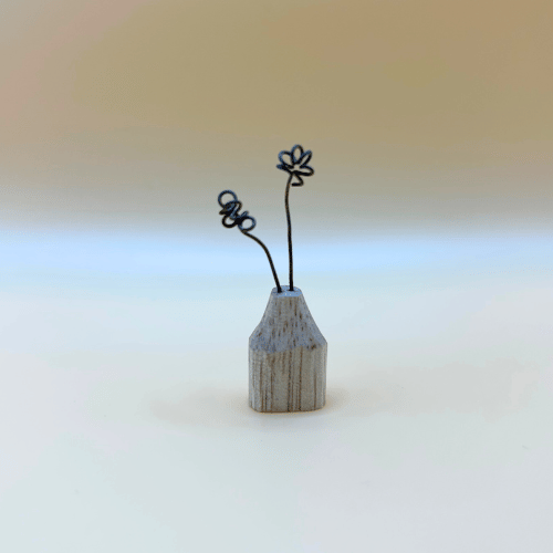 Small wooden vase with wire flowers on a gradient background