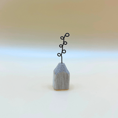 Small wooden vase with a black wire plant on a gradient background