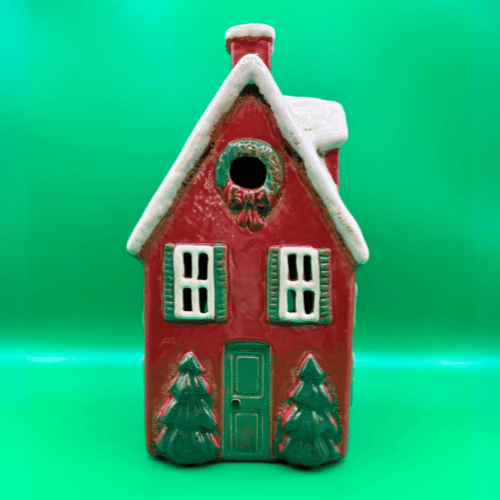 Tall red ceramic tea light candle house, snowy roof with dormer windows, christmas trees at door and a wreath. | Christmas Decor