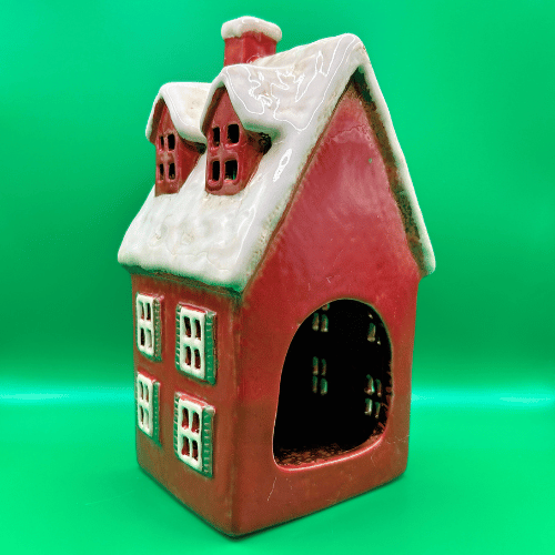 Tall red ceramic tea light candle house, snowy roof with dormer windows, christmas trees at door and a wreath. | Christmas Decor